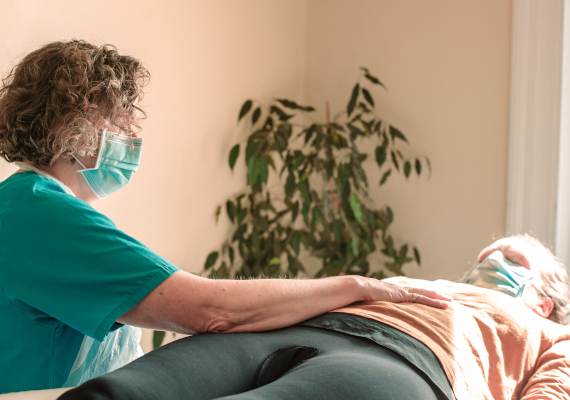 A massage therapist massaging a woman's shoulders